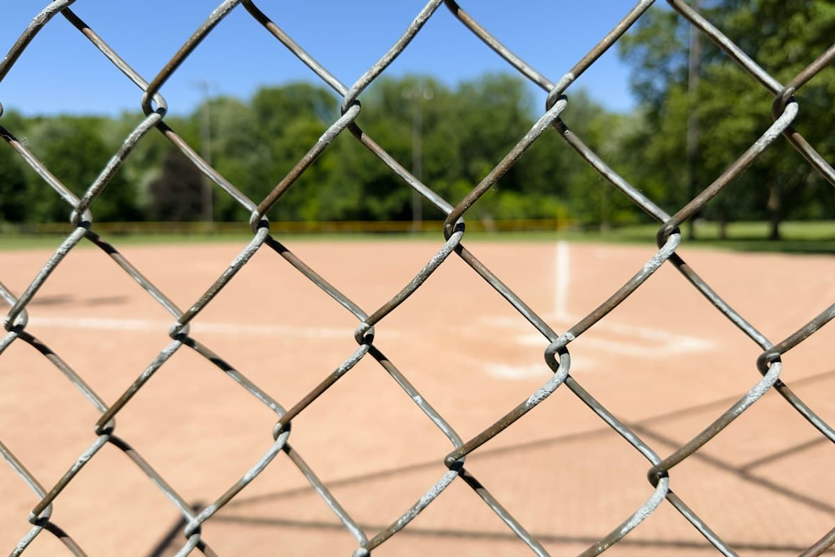 Vedação em malha metálica a delimitar um recinto desportivo